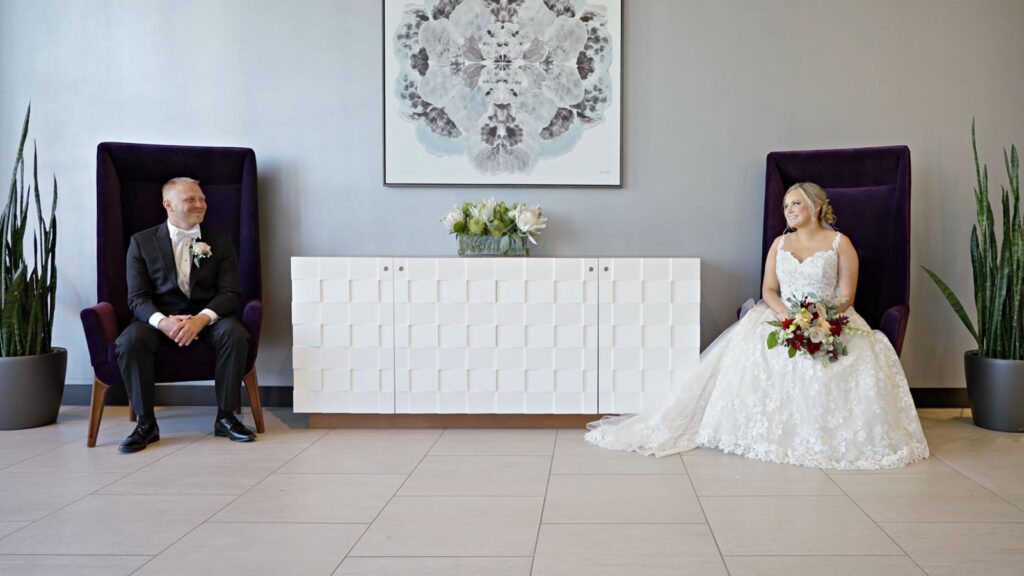 J Powers At The Hilton Wedding Bride and Groom seated in Large purple chairs.
