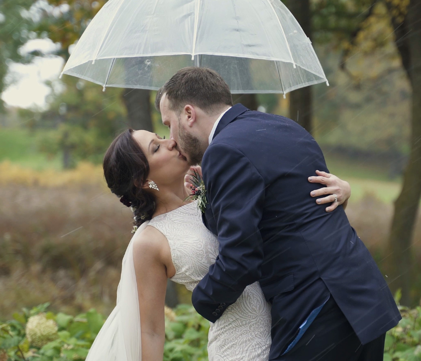 Bearpath Weddin Bride and Groom Kiss Outside Under An Umbrella During An Ice Storm