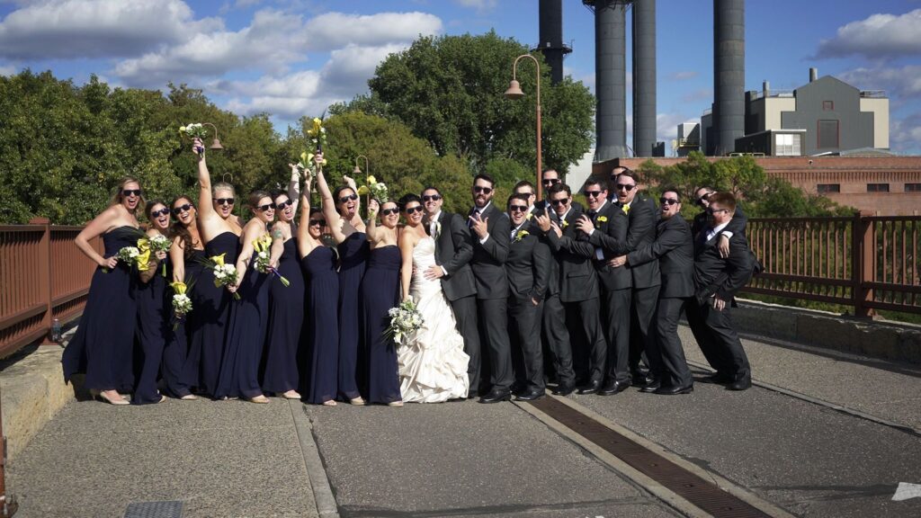 Minneapois Radisson Blu Wedding Wedding Party Poses on Stone Arch Bridge in Minneapolis